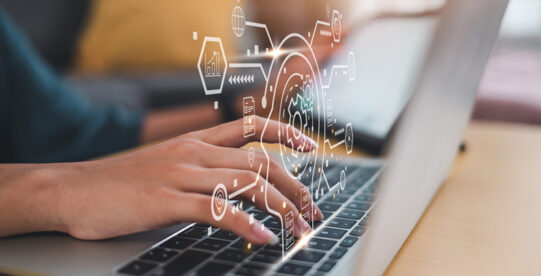 Woman typing in an laptop with data graphics emerging form the keyboard