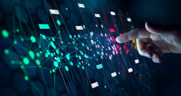 Concept art of a pointing finger touching colorful data points on a black screen
