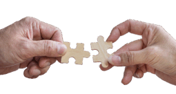 Two hands connecting puzzle pieces together