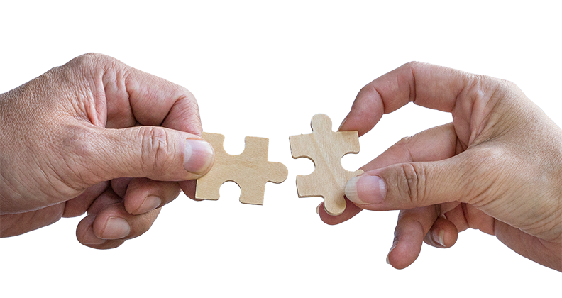 Two hands connecting puzzle pieces together