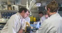 OSSTEC team members huddled around 3D printed devices