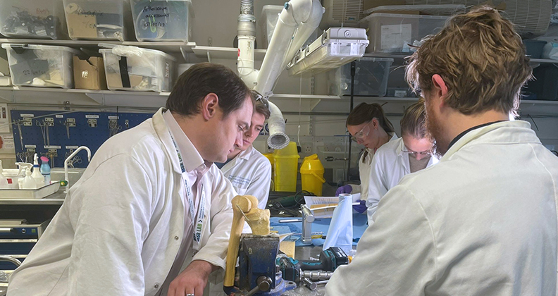 OSSTEC team members huddled around 3D printed devices