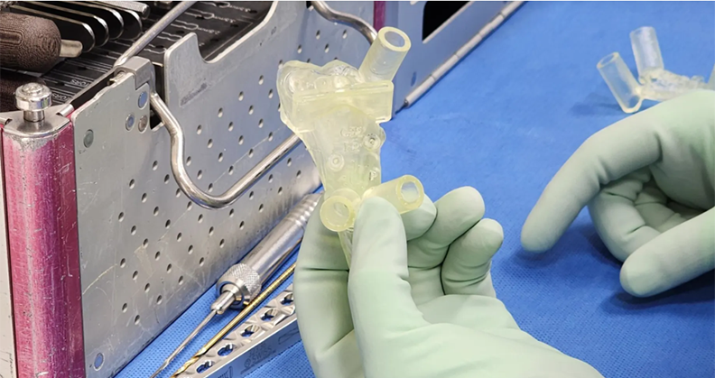 A gloved hand holding a 3D-printed implant
