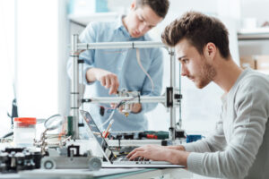 Stock art showing design engineers at a laptop and a 3D printing machine.