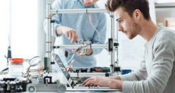 Guy working on a a laptop in a lab to represent 3D printing