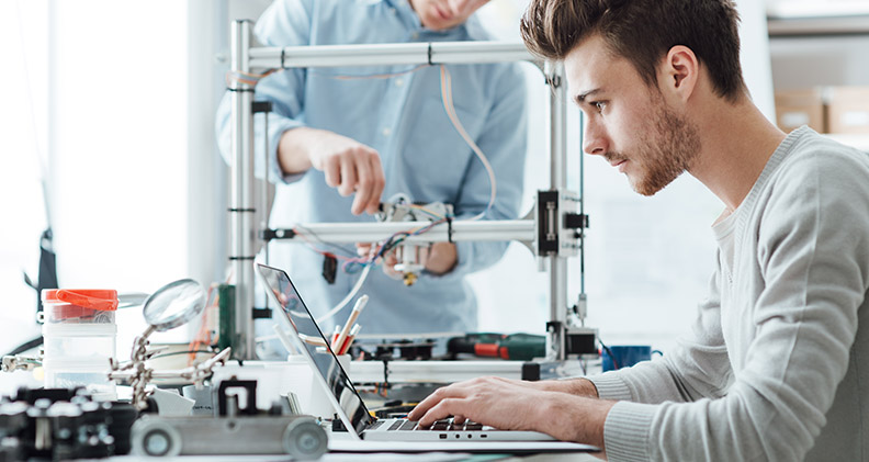 Guy working on a a laptop in a lab to represent 3D printing