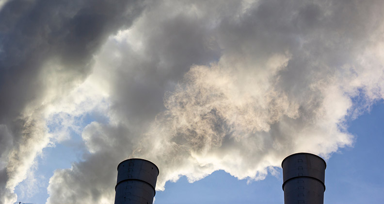 two smoke stacks spewing emissions