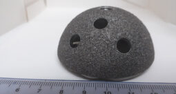 Acetabular cup implant with a ruler along the bottom of the image