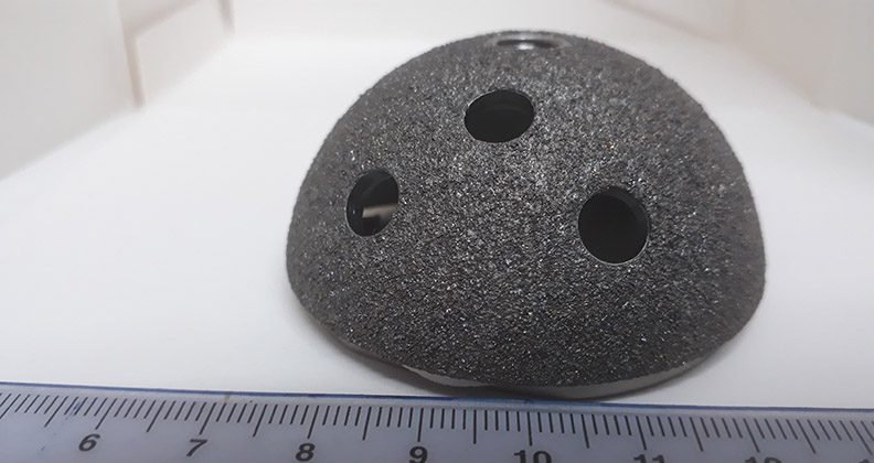 Acetabular cup implant with a ruler along the bottom of the image