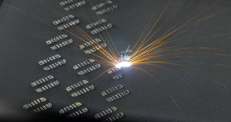 Sparks flying off 3D printed implants against a black background