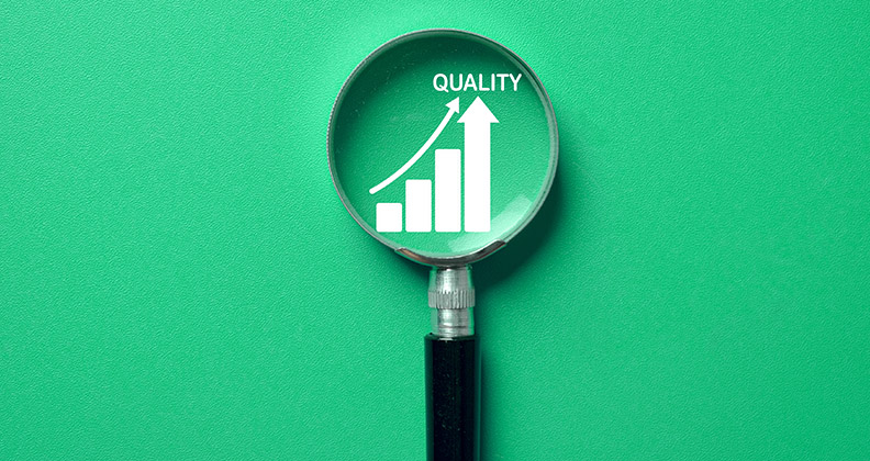 Magnified glass focused on the word quality against a light green background