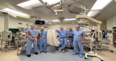Group of surgeons on blue scrubs standing around a C-arm