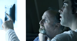 guy with hand to chin looking at spine x-ray