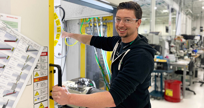 A smiling Autocam worker on the manufacturing floor