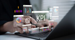 Hands typing on a keyboard with charts and KPI graphics overlays